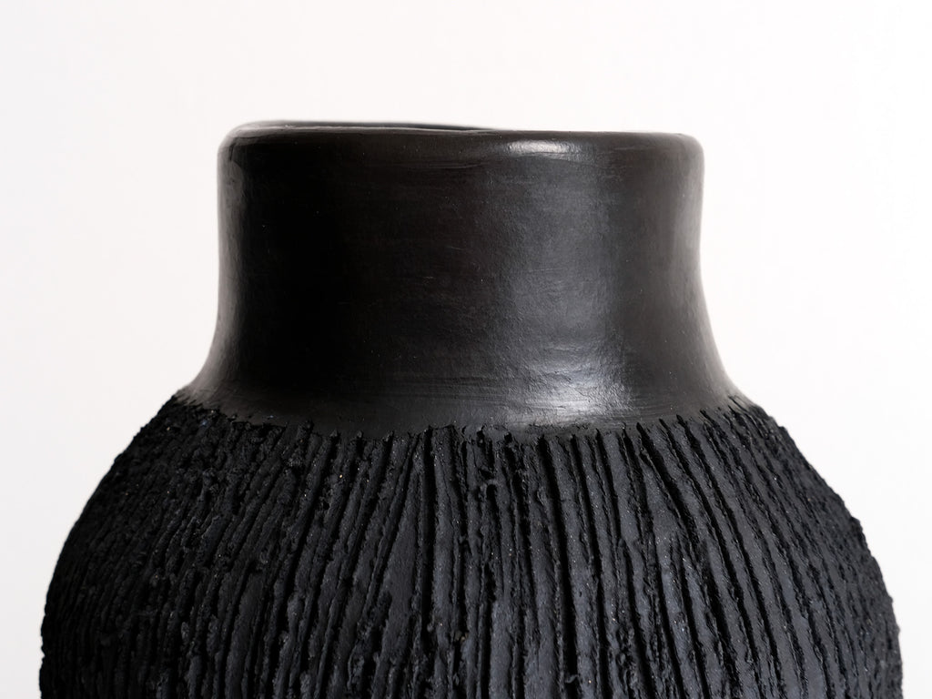 Black textured vase on a white background