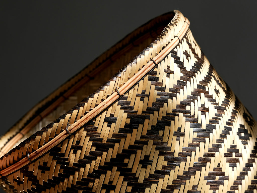 Close-up of a woven basket with a geometric pattern on a dark background