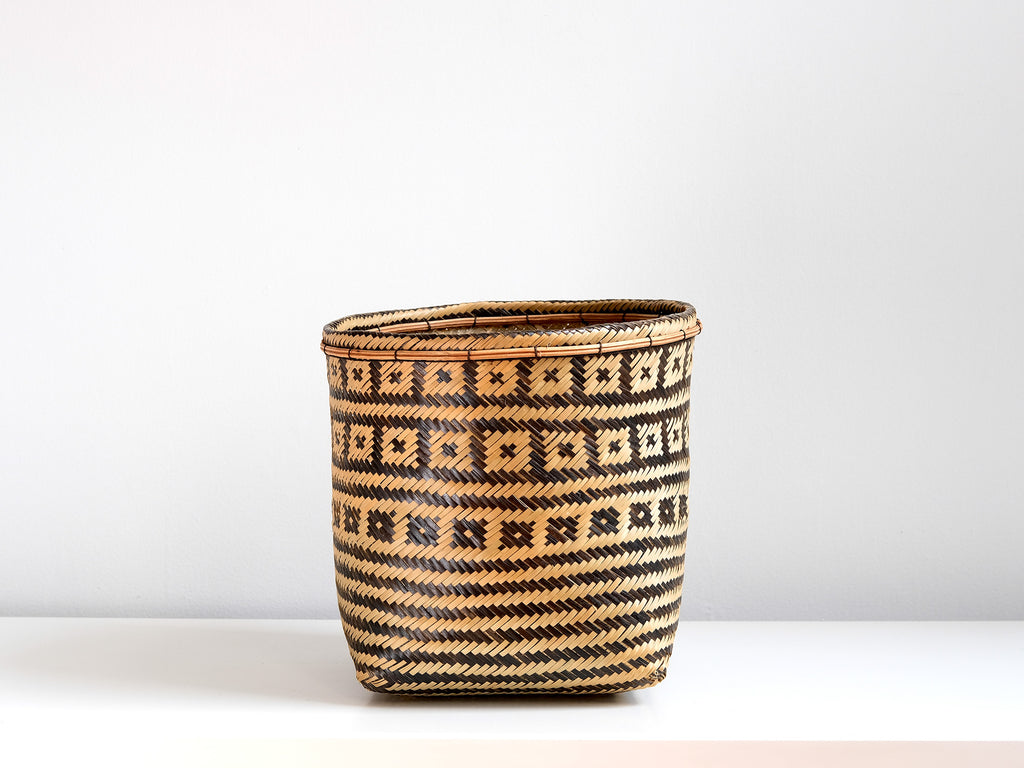 Woven basket with geometric pattern on a white background